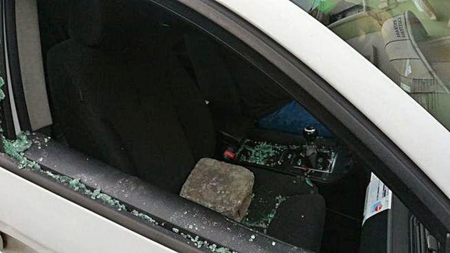 Una piedra en un coche al que rompió una luna en un robo.