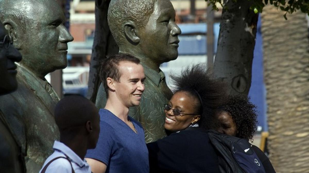 Una mujer abraza la estatua de Nelson Mandela en Ciudad del Cabo.