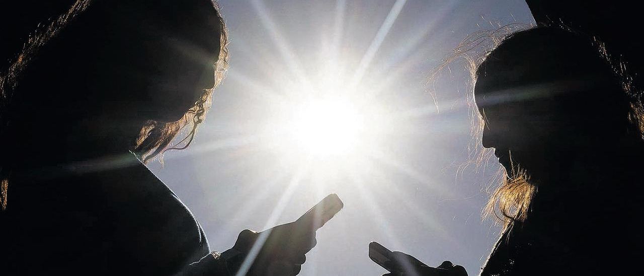 Dos jóvenes utilizan el móvil, uno de los dispositivos que se asocia con el auge de los errores ortográficos.