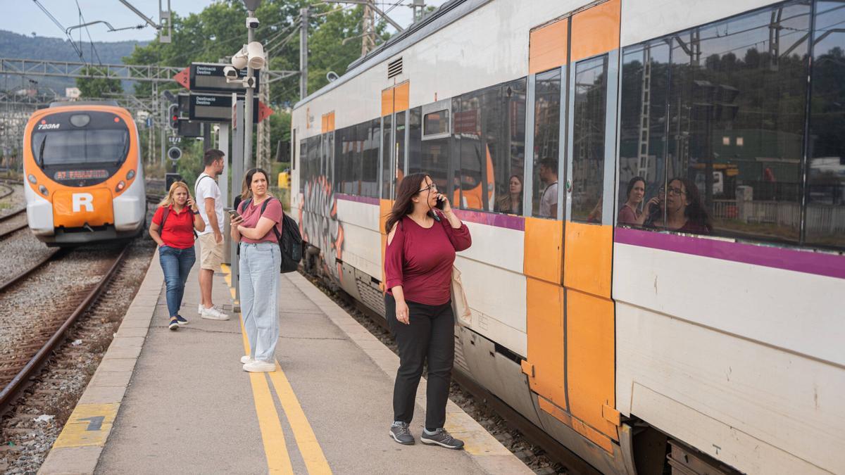 Imagen de archivo de pasajeros junto a un tren de Rodalies.