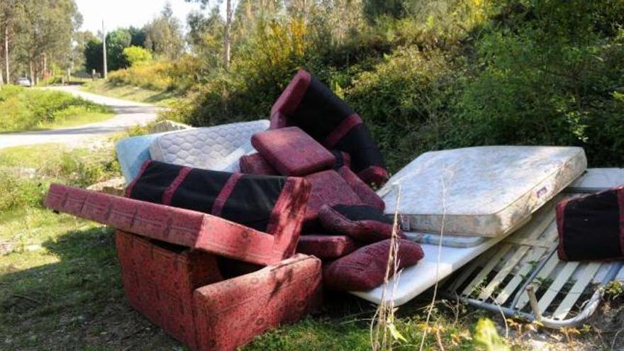 Varios sofás, colchones y somieres fueron abandonados en el monte de Combarro. // Gustavo Santos