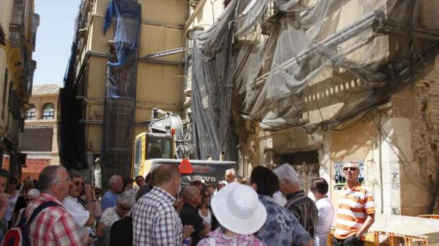 Un grupo de turistas pasaba ayer por las obras paradas del futuro hotel de cinco estrellas en la calle Granada.