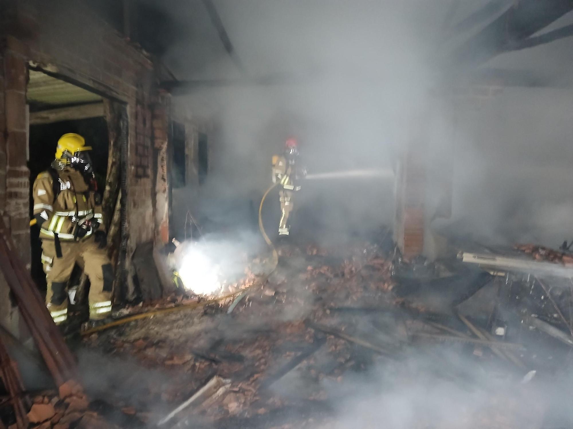 Bomberos de Santa Comba extinguiendo el incendio del alpendre en A Baña.