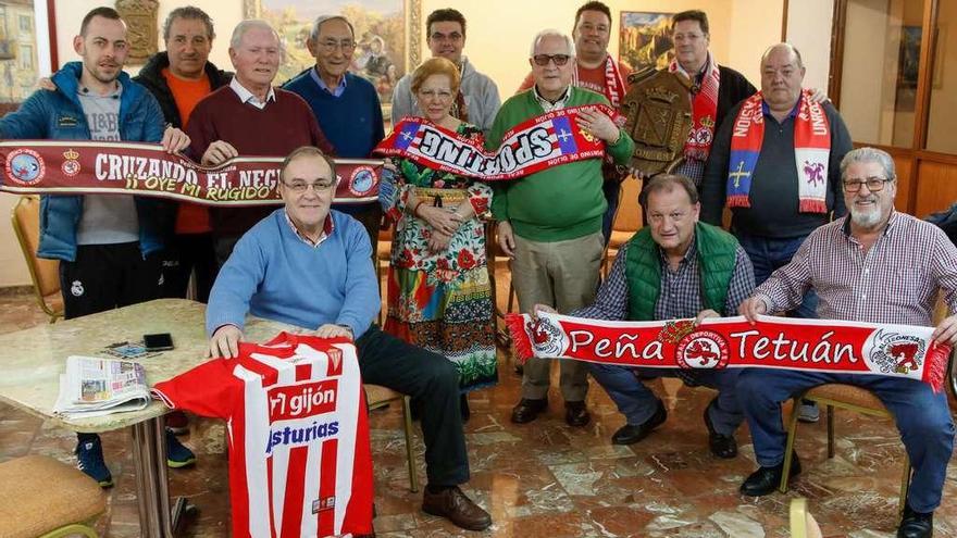 Algunos miembros de la Casa de León de Asturias posan con camisetas y bufandas del Sporting y la Cultural Leonesa en su sede.