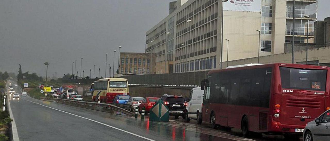 Largas colas para acceder al hospital en un día lluvioso.