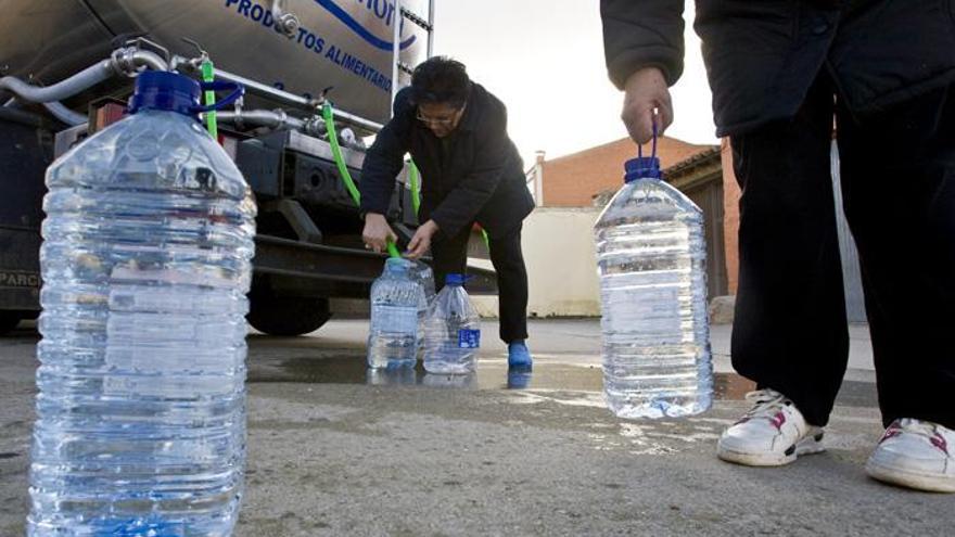 Varias personas recogen agua potable de camiones cisterna