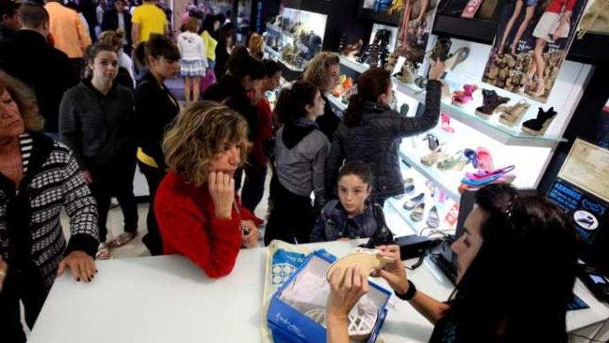 Empleada de un comercio, con la tienda llena en Semana Santa.