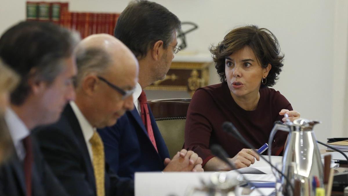 Soraya Sánez de Santamaría conversa con Rafael Catalá, junto al ministro Cristóbal Montoro e Íñigo de la Serna al inicio del Consejo de Ministros extraordinaro para fijar las bases de la aplicación del 155