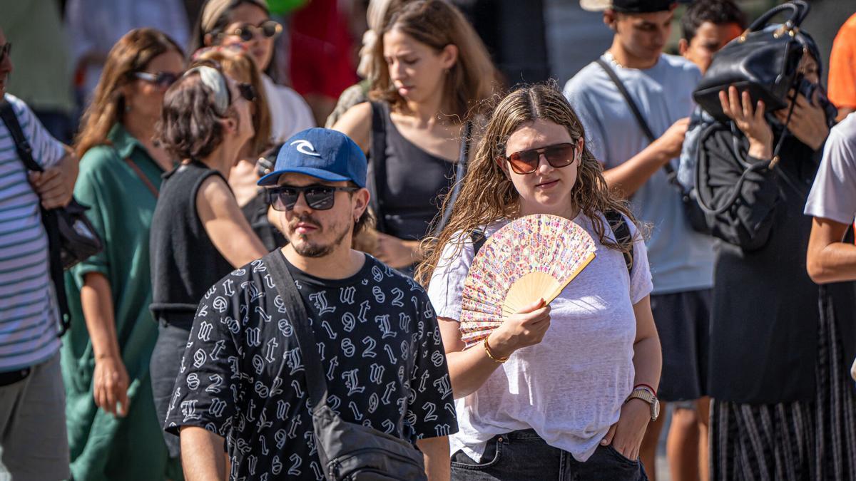 Turistas paseando por Barcelona con temperaturas elevadas.
