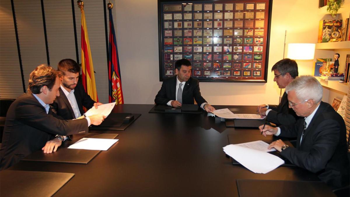 Arturo Canales (primero por la izquierda) junto a Gerard Piqué y Josep Maria Bartomeu en la firma de la renovación de contrato del futbolista