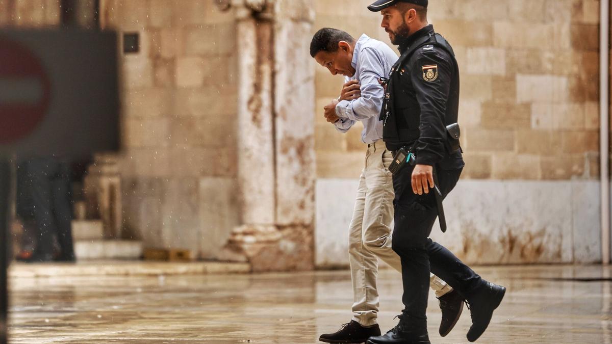 El acusado es conducido por un agente de la Policía Nacional a la sala donde se ha celebrado el juicio.