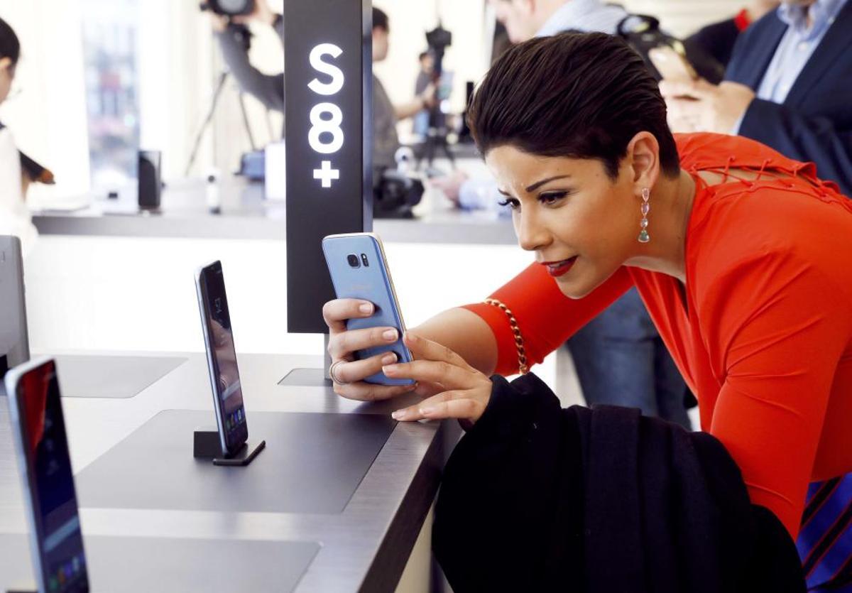 A woman takes a picture of the Samsung Galaxy ...
