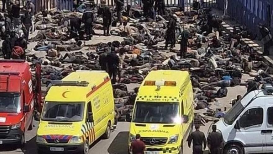Policías de Marruecos junto a inmigrantes amontonados, algunos fallecidos, tras el intento de salto a Melilla en junio.