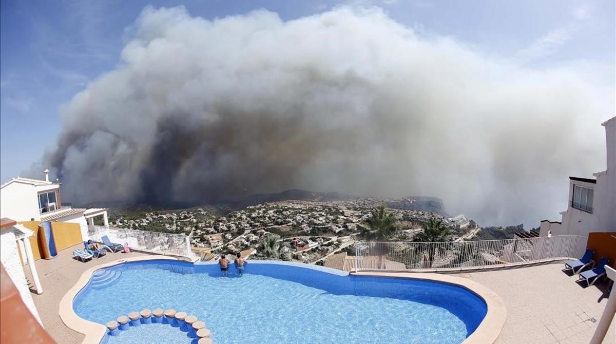 icoy35393734 two men look at a wildfire from a swimming pool as it burns 160905200353