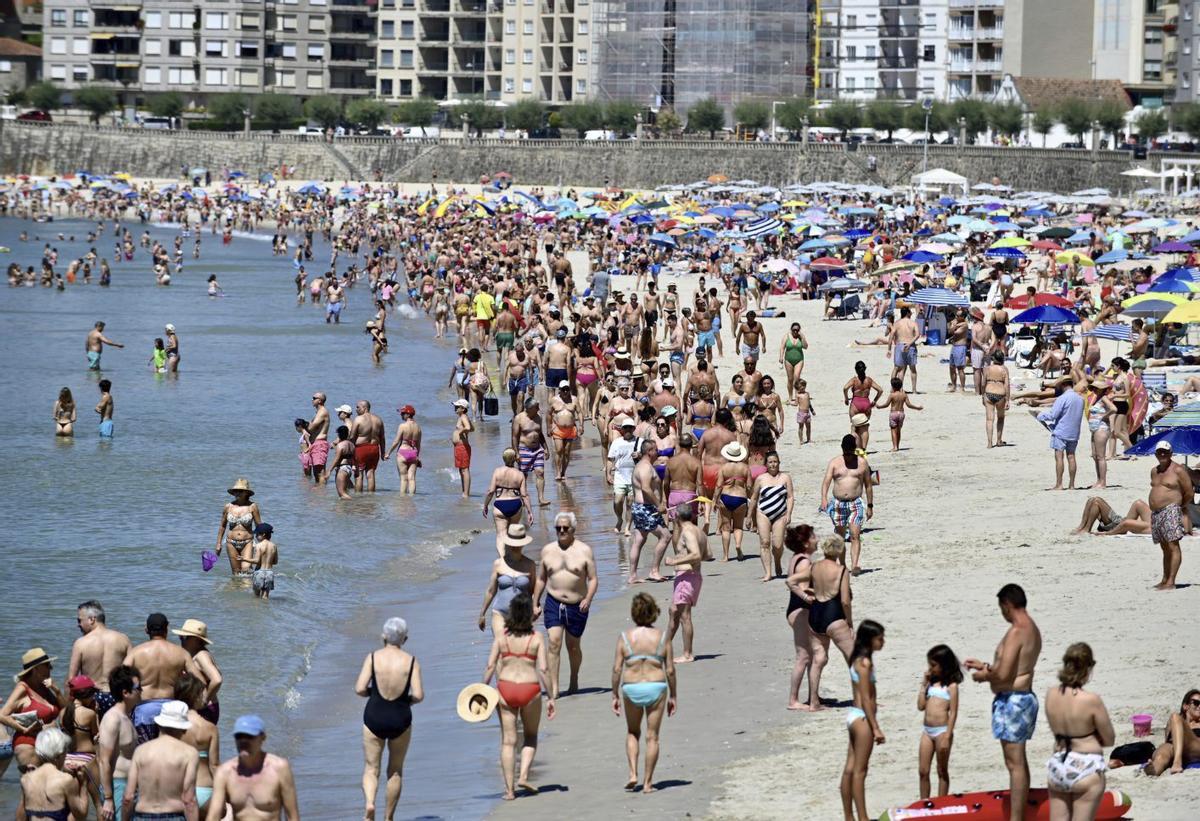 Bañistas y turistas en la playa de Silgar, en Sanxenxo, el pasado mes de julio.  | RAFA VÁZQUEZ