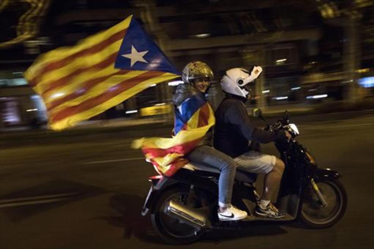 Dos independentistas en moto ondean una ’estelada’ el 17 de octubre en Barcelona.