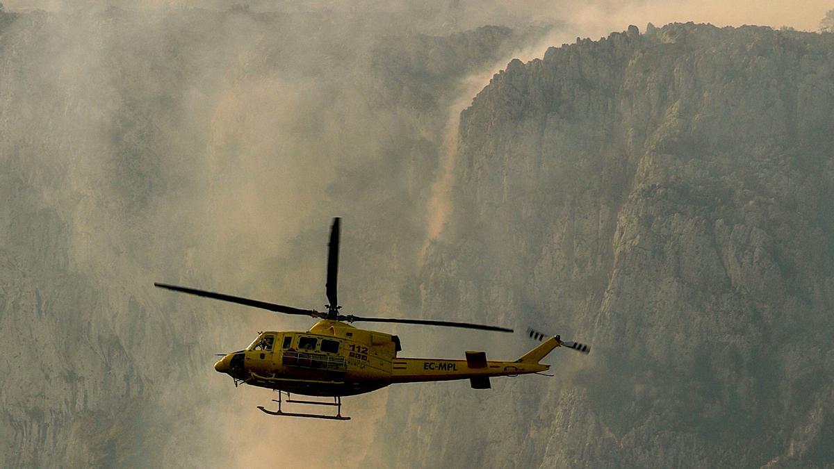 Uno de los helicópteros que sobrevuela la superficie del noreste de Alicante para apagar el incendio.