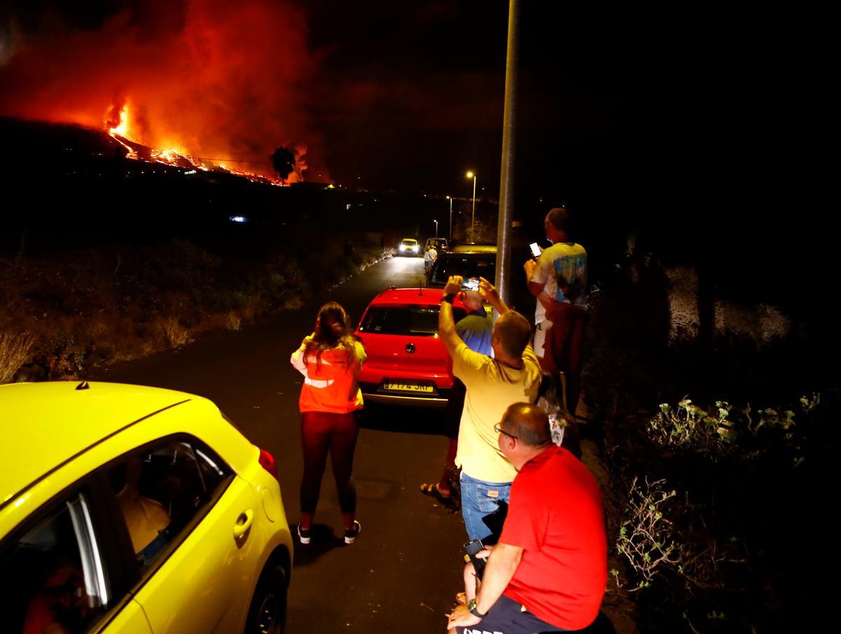 REsidents watch lava following the eruption of a volcano in Spain