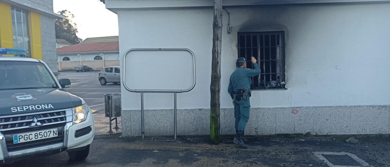 Un agente de la Guardia Civil inspecciona el interior de la caseta de Portos de Galicia.