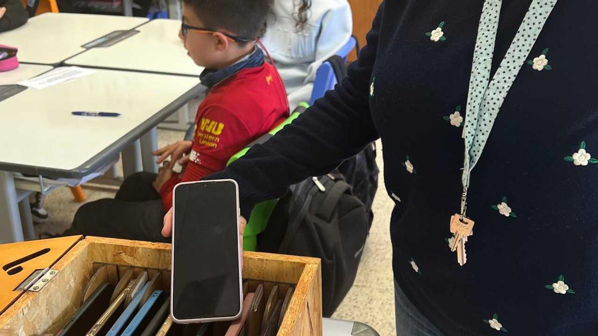 Una mestra de Ripoll amb la caixa dels mòbils a l'aula.