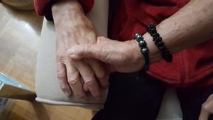 Un familiar coge la mano de una persona con alzhéimer.