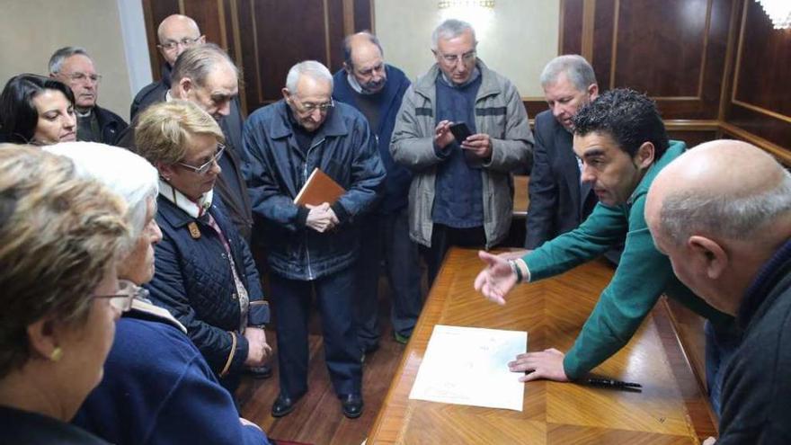 Tras la firma del convenio, López explica a vecinos y clérigos la ubicación del templo. // Bernabé/Gutier