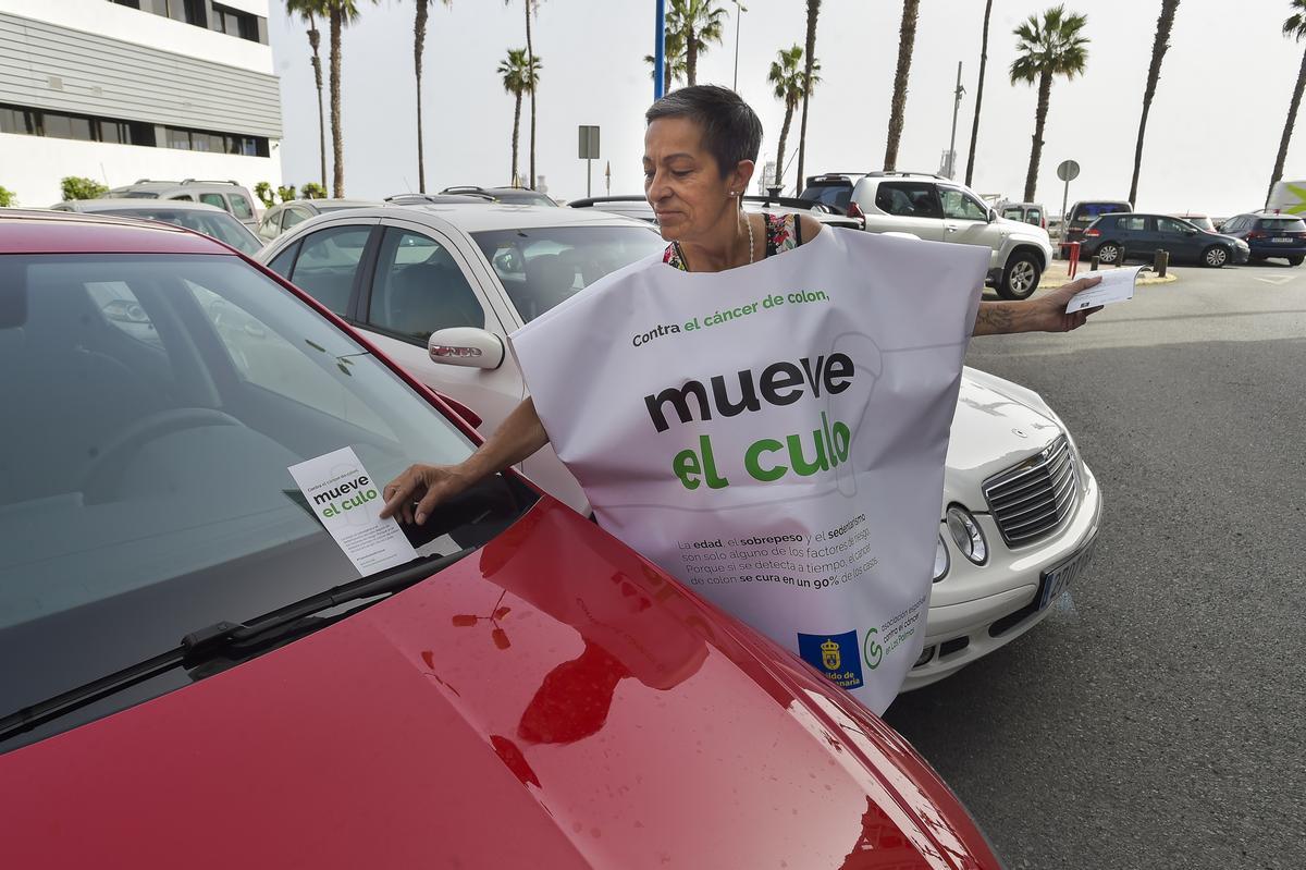 Una voluntaria repartiendo el folleto de la campaña 'Mueve el culo' por el Día Mundial para la Prevención del Cáncer de Colon