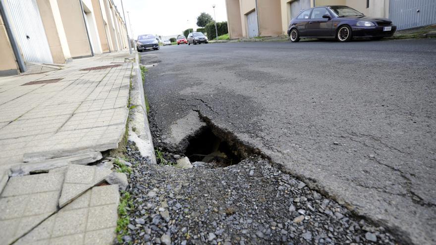 Urgen el arreglo de los socavones del vial de las viviendas sociales de Merlín