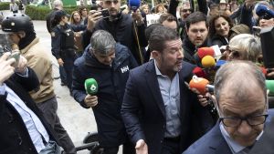 Emilio Argüeso, en el centro sin corbata, accede a la Ciudad de la Justicia rodeado de periodistas junto a su abogado.