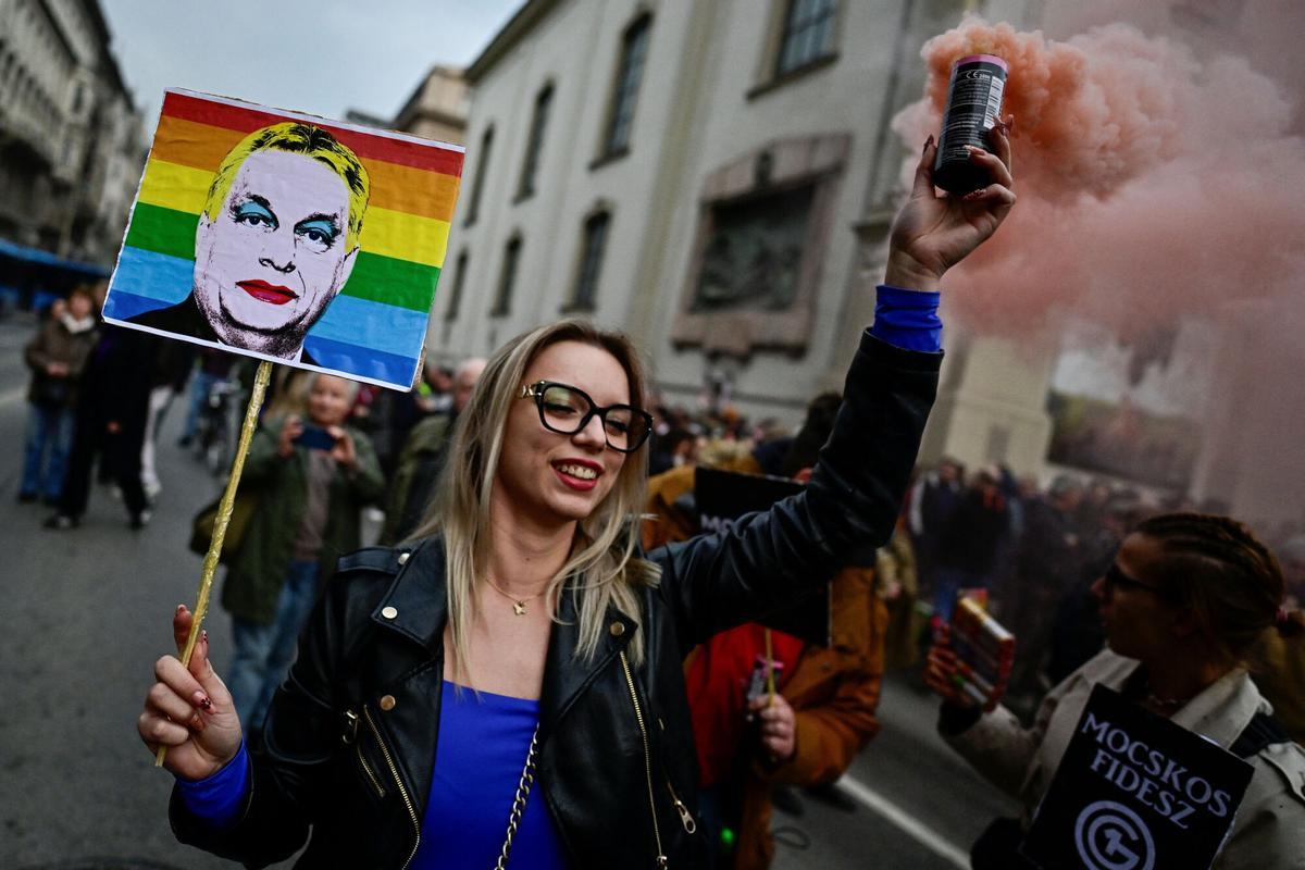 Una mujer sostiene una pancarta que representa al primer ministro de Hungría, Viktor Orban, durante una manifestación después de que el Parlamento húngaro aprobara una ley que prohíbe a las comunidades LGBTQ+ celebrar la marcha anual del Orgullo y permite una restricción más amplia de la libertad de reunión, en Budapest