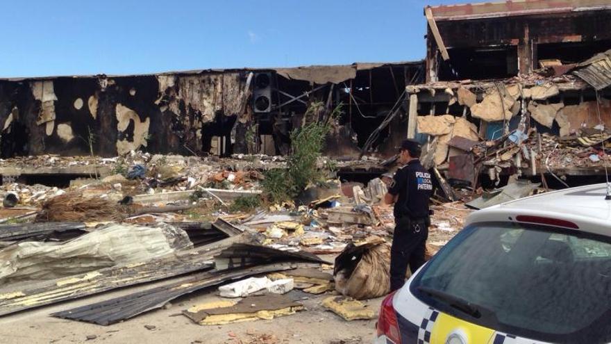 Un policía supervisa el recinto quemado.