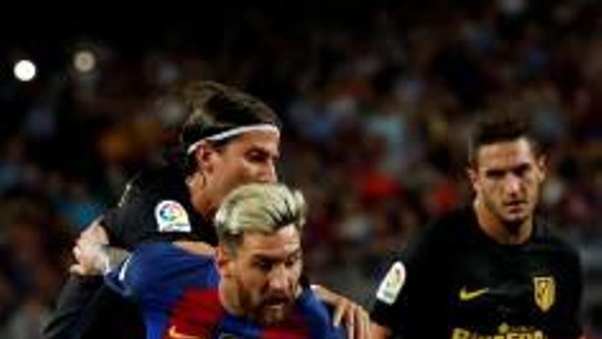 Filipe Luis intenta frenar Messi.