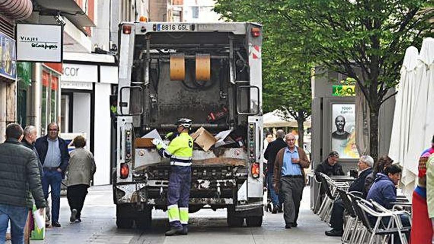Un operario recoge basura en una calle de la ciudad.