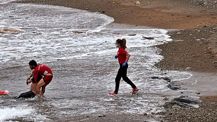 Socorristas de Gijón sacan al herido del mar en la playa de El Rinconín. | J. Coletes