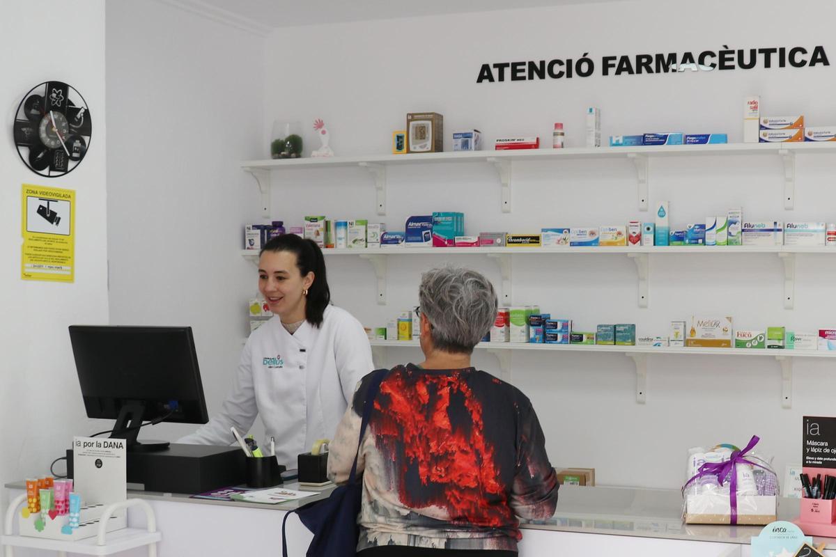 Una farmacéutica atiende a una paciente en Bellús.