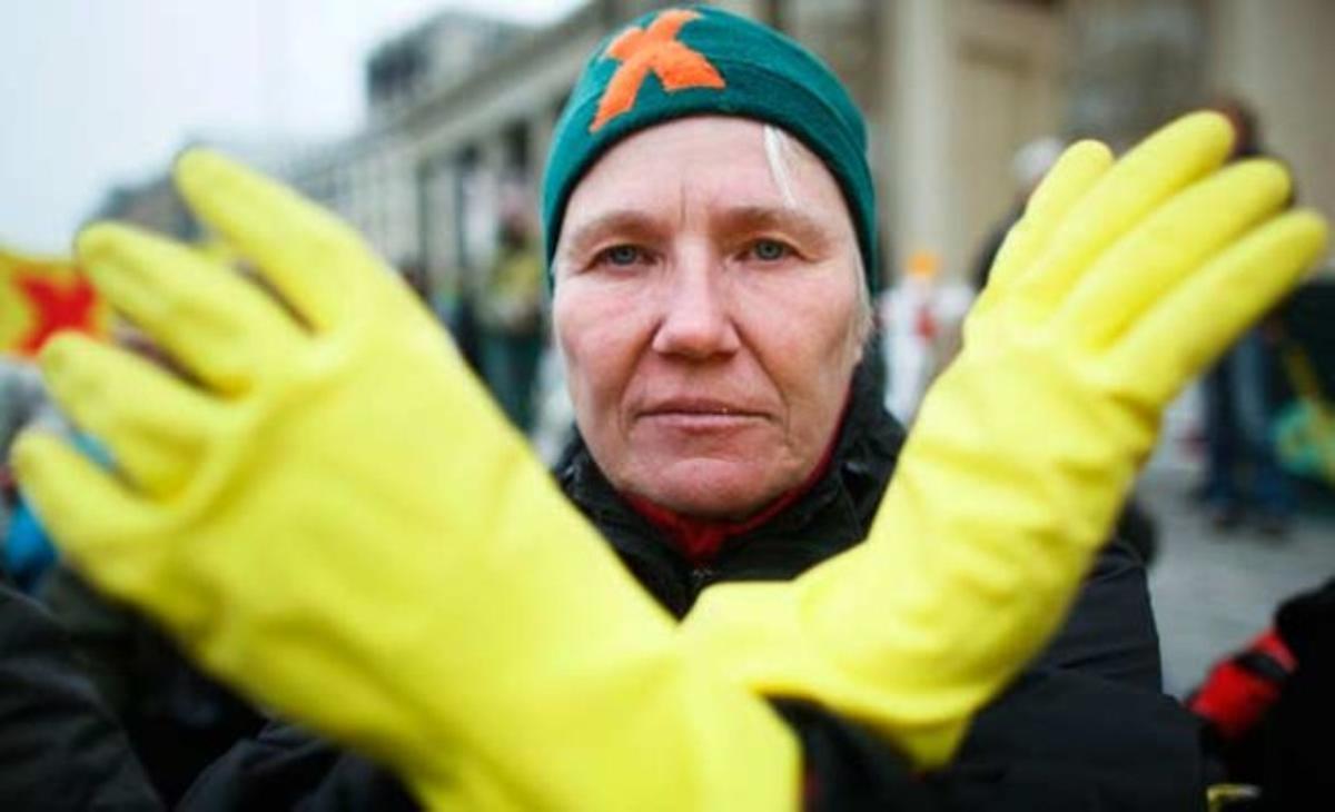 Una mujer con guantes amarillos cruza sus brazos formando una X durante una protesta antinuclear en Berlín. La X amarilla representa al movimiento que busca paralizar el transporte de residuos nucleares al cementerio nuclear de Gorleben, en el noreste de Alemania.