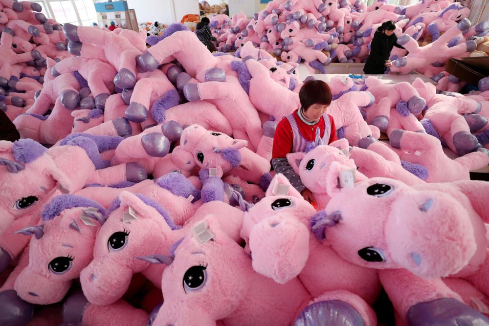 Women work on unicorn stuffed toys for export at ...