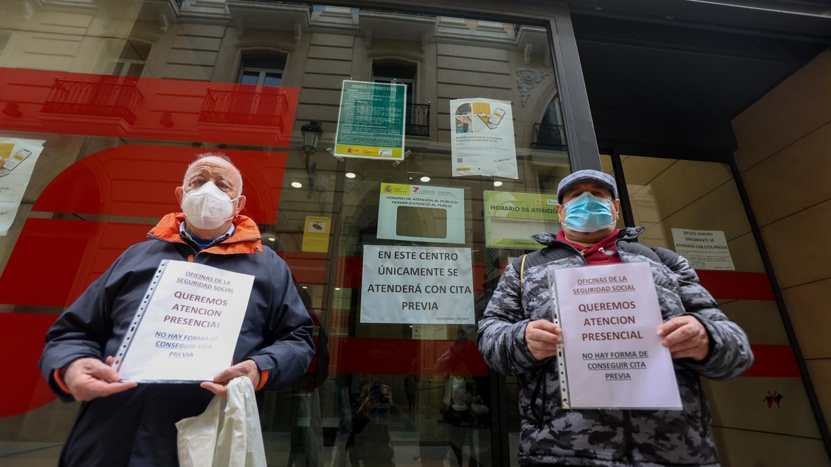 Dos alicantinos protestan, el pasado abril, ante una oficina de la Seguridad Social en Alicante por la falta de atención presencial