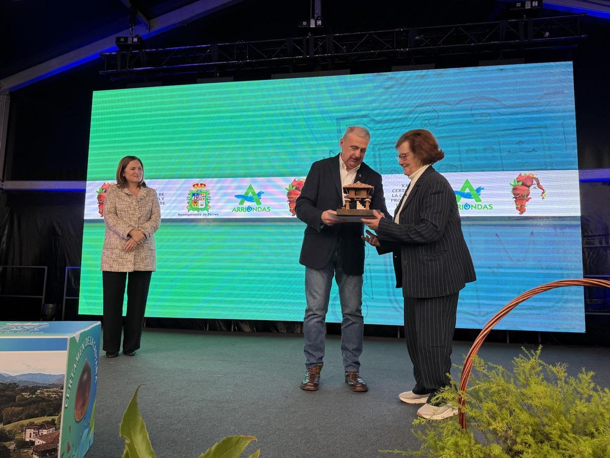 Hortensina González redcibe el primer premio del Certamen de la castaña de Parres de manos del alcalde, Emilio García Longo.