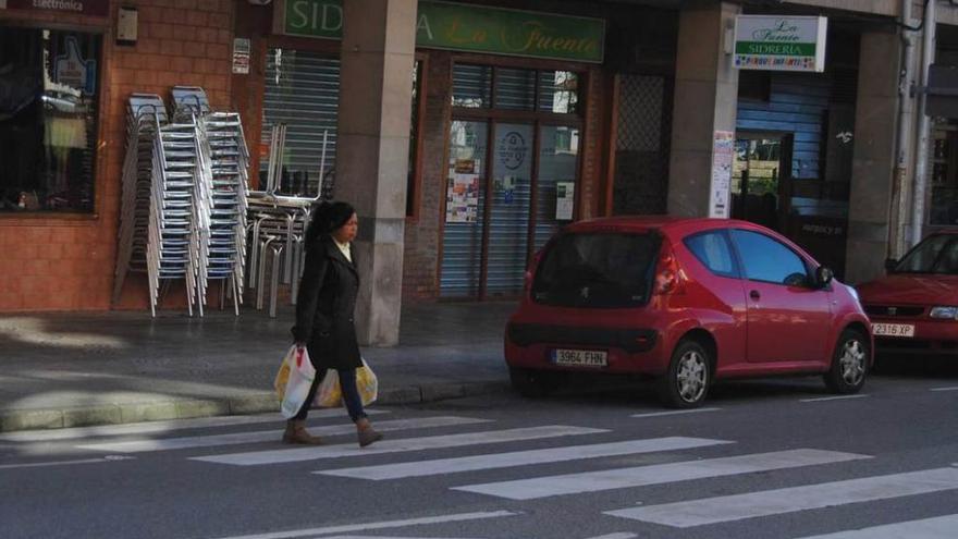Una mujer cruza por un paso de peatones de Lugo con la acera sin rebajar.
