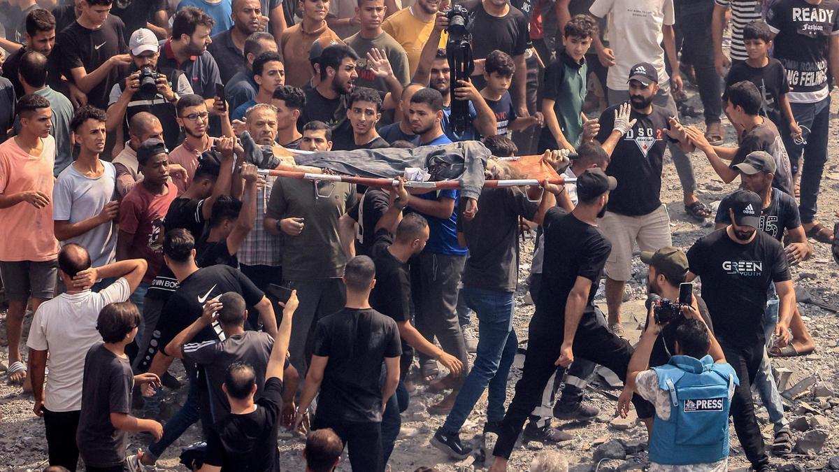 Palestinos evacúan cuerpos de los escombros tras un ataque aéreo israelí a la mezquita de Sousi, en la ciudad de Gaza.
