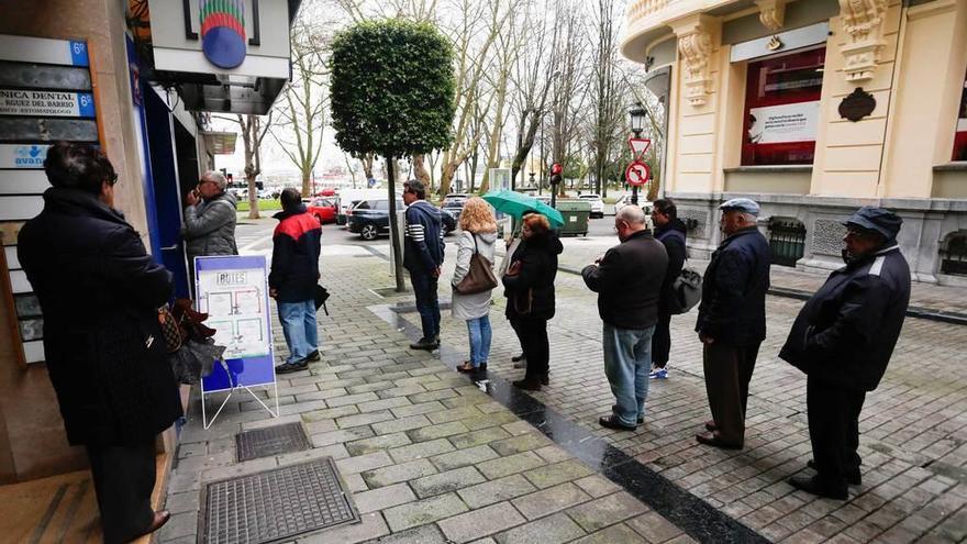 Varias personas hacen cola a la puerta de la administración de lotería de la calle Carreño Miranda.