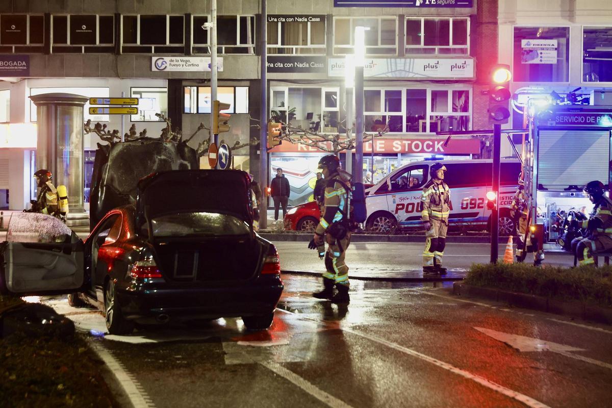 Alarma en Gijón por un coche ardiendo en la plaza del Humedal (en imágenes)