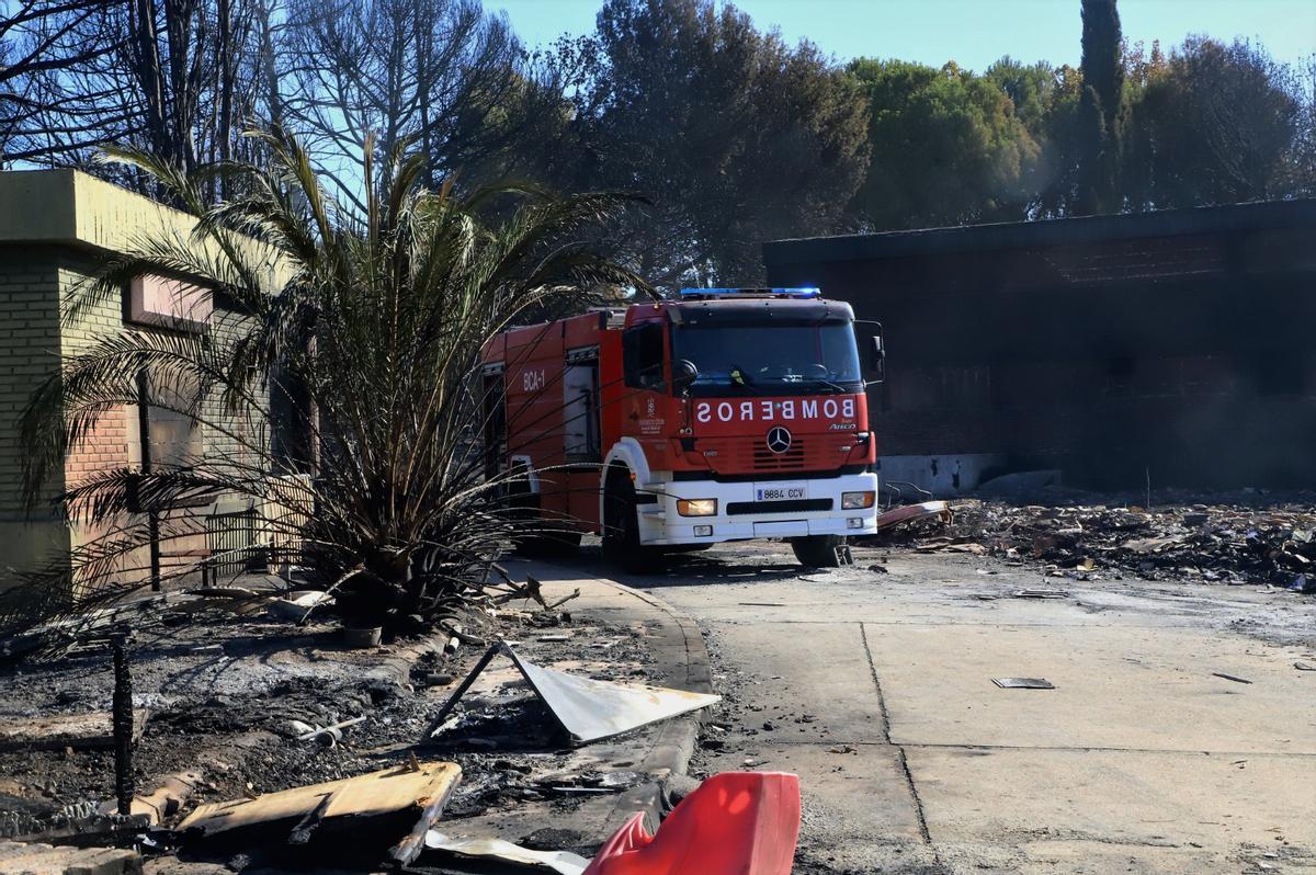 Un coche de bomberos este lunes, junto a los restos calcinados tras el incendio en Chinales.