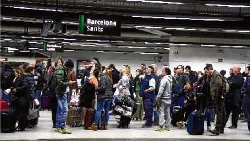 Usuaris afectats per la vaga de Renfe d&#039;aquesta setmana, consultant les pantalles a l&#039;estació de Sants.