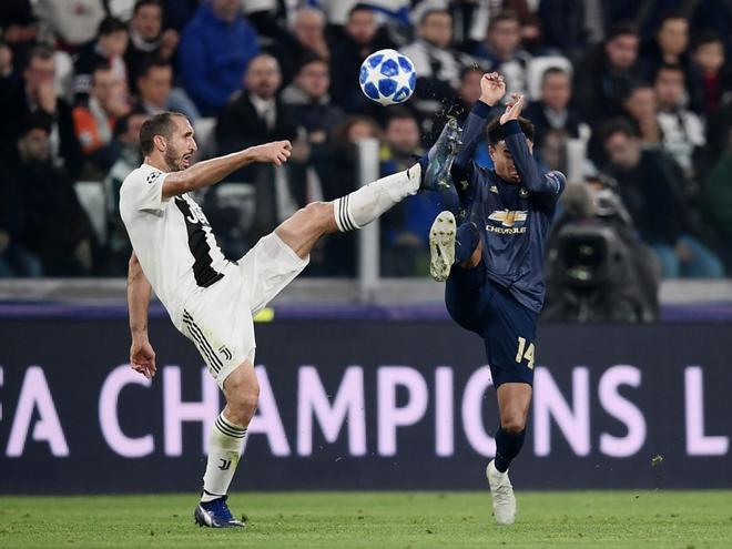 El jugador de la Juventus Giorgio Chiellini (L) y el del Manchester United English Jesse Lingard durante el partido de la UEFA Champions League entre la Juventus y el Manchester United en el Allianz stadium en Turin.
