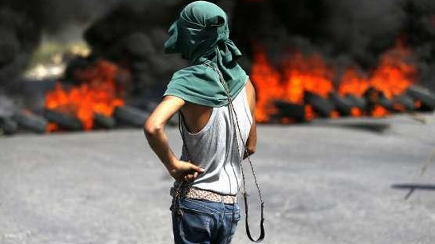 Un joven palestino sostiene una honda durante una protesta en el asentamiento judío de Beit El, próximo a la cisjordana Ramala.
