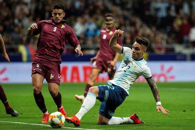 El delantero de la selección de Argentina, Lautaro Martínez (d), disputa el balón ante el centrocampista de Venezuela, Júnior Moreno (i), durante el encuentro amistoso que disputan esta noche en el estadio Wanda Metropolitano, en Madrid.