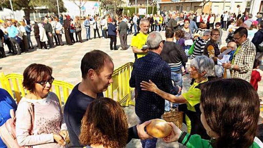 Repartiment dels panets beneïts ahir al matí a la plaça de l&#039;Onze de Setembre, on es va celebrar l&#039;aplec