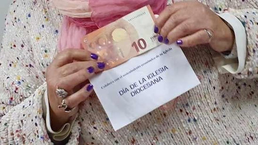 María Ángeles Costales sostiene el sobre con los 10 euros.